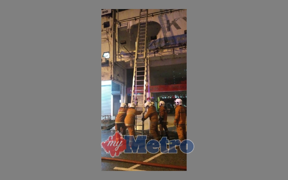 Anggota bomba menggunakan tangga untuk menyelamatkan tiga mangsa di tingkat atas. FOTO ihsan bomba
