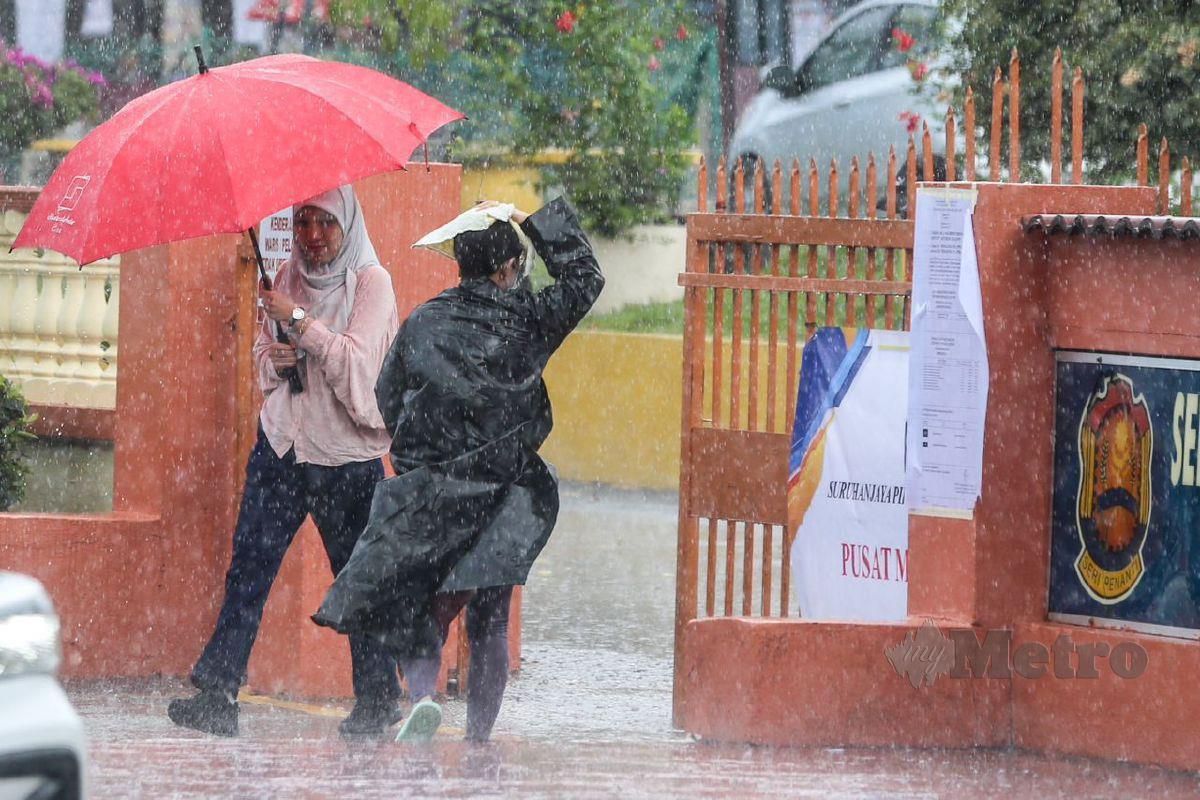 Pengundi hadir ketika hujan bagi menunaikan tanggungjawab di SK Seri Penanti, Kubang Semang bagi kerusi Dun Permatang Pasir. FOTO Danial Saad