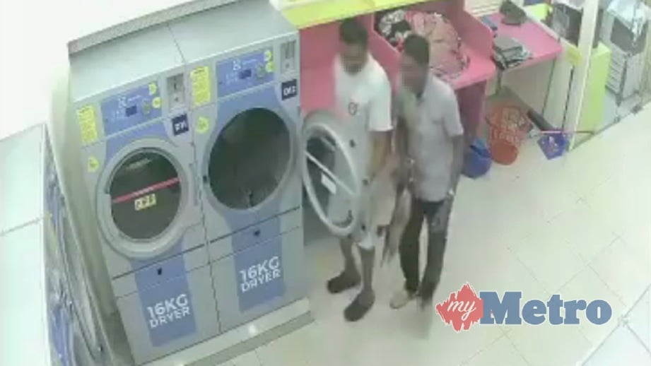 PETIKAN rakaman CCTV menunjukkan dua  lelaki memasukkan kucing betina terbiar yang sedang bunting  ke dalam mesin pengering di kedai dobi. FOTO Persatuan Haiwan Malaysia