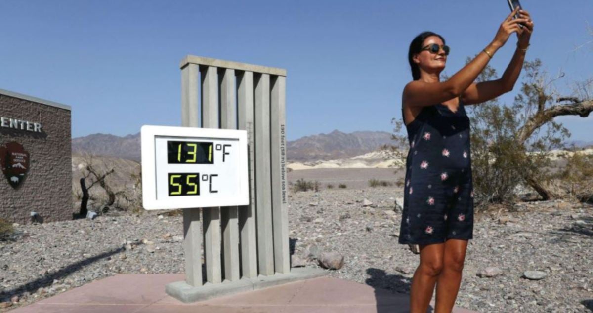 PELANCONG merakamkan gambar berlatar papan suhu di Death Valley. FOTO AFP 