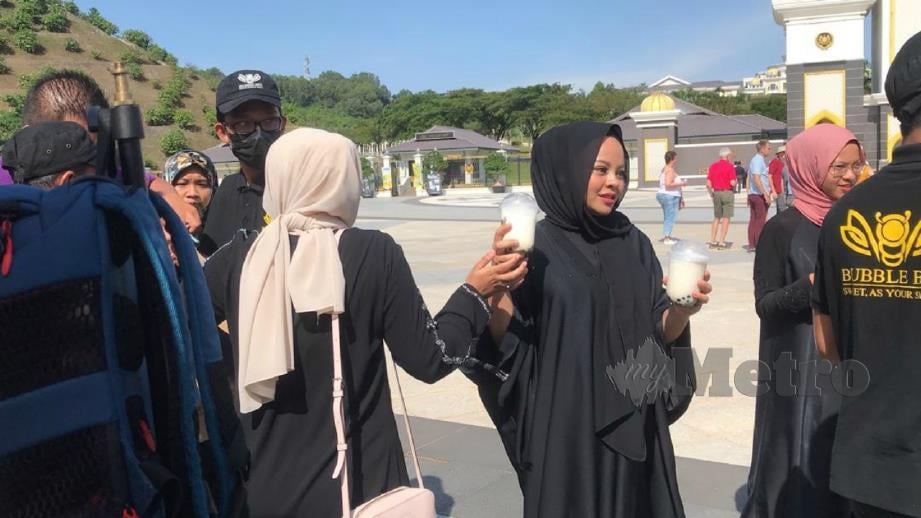 Siti Sarah edar minuman kepada petugas media di Istana Negara. FOTO Murnaena Muhammad Nasir