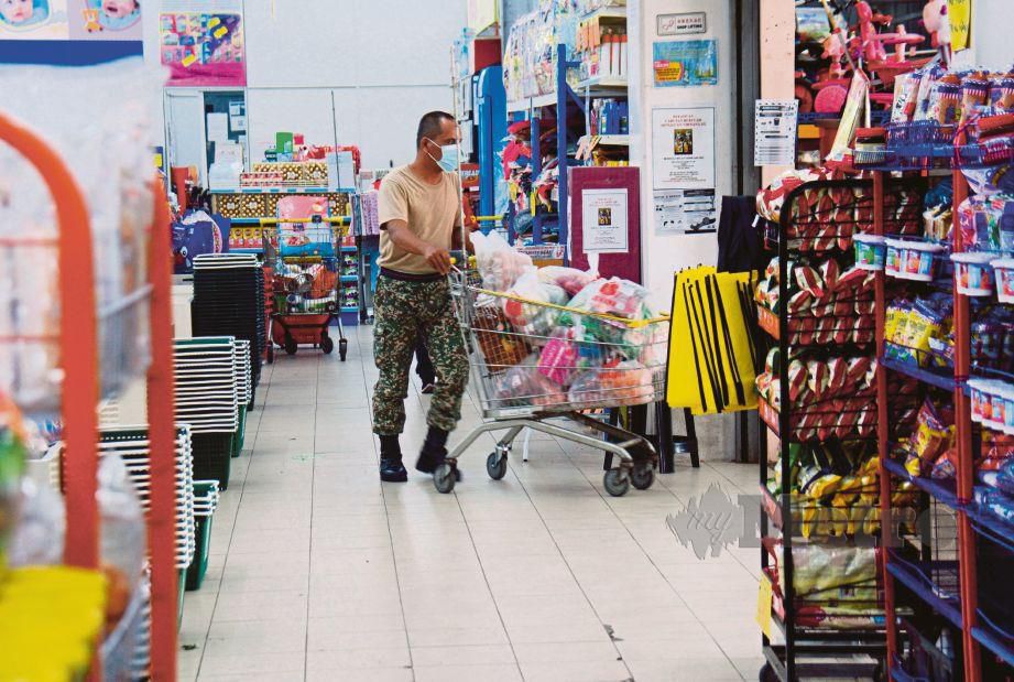 ANGGOTA tentera dilihat menolak troli yang dipenuhi barang makanan di sebuah pasar raya di Kuantan. FOTO Bernama