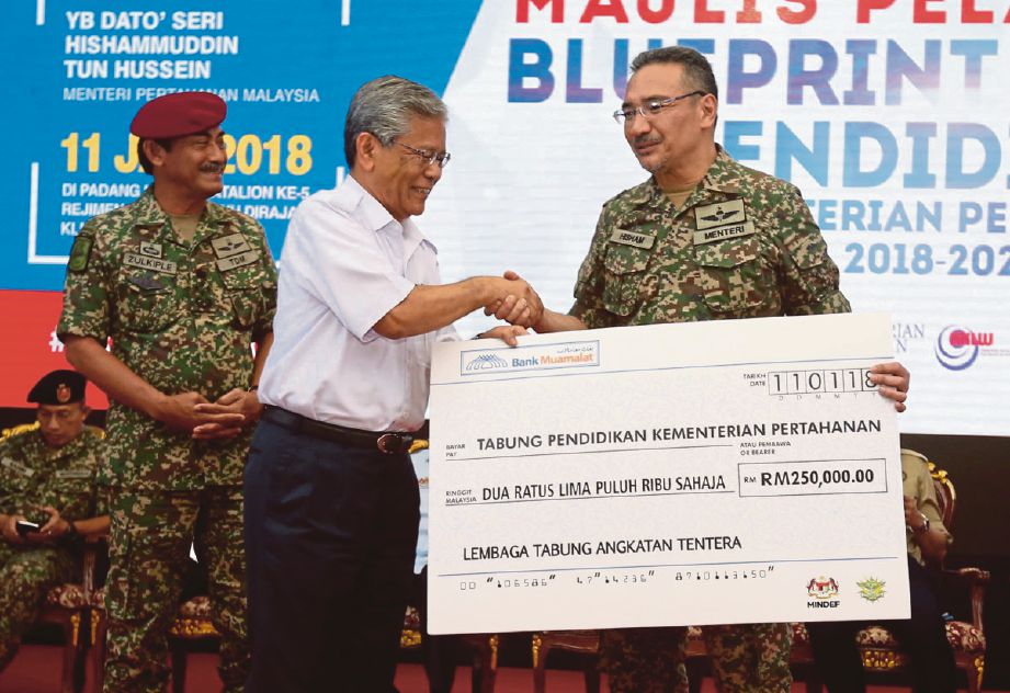 HISHAMMUDDIN  (kanan)  menyampaikan penghargaan kepada penyumbang Tabung Amanah Pendidikan Kementerian Pertahanan, wakil kepada Lembaga Tabung Angkatan Tentera, Tan Sri Lodin Wok Kamaruddin.