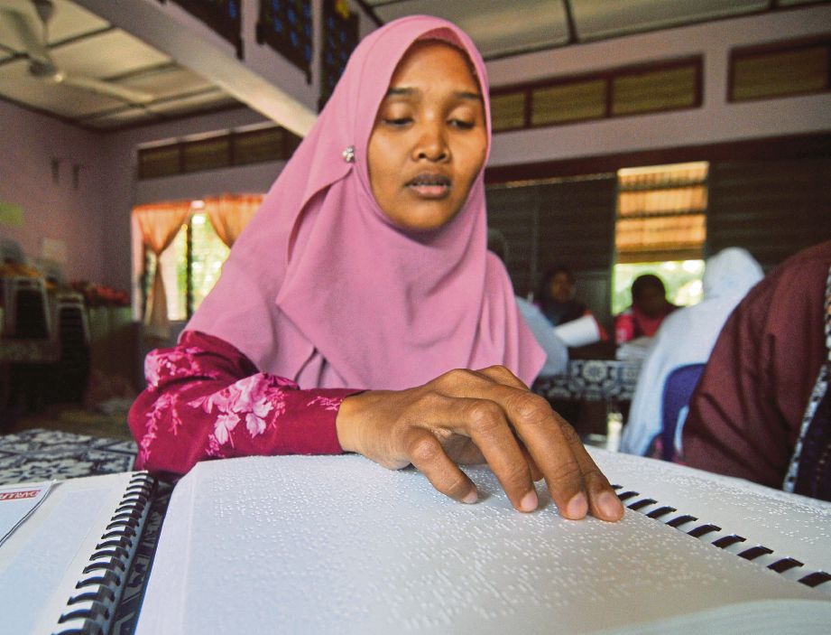 SITI Noor mampu membaca al-Quran braille yang digunakan  OKU penglihatan.
