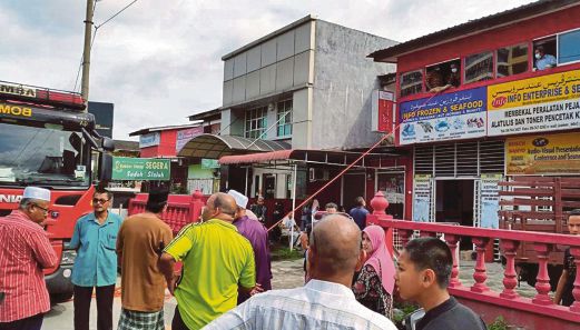 ANGGOTA bomba membawa turun jenazah Zaima melalui tingkap ditingkat satu sebuah premis perniagaan di Jalan Bayam, Kota Bharu. 