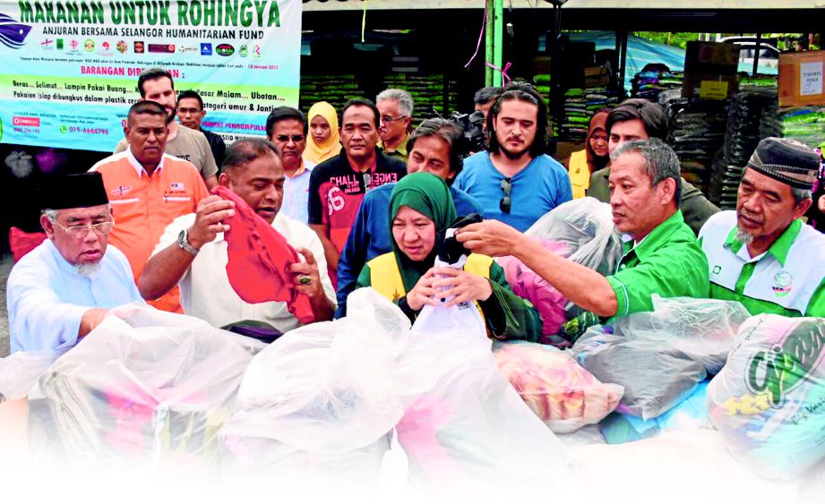 ABDUL Azeez (depan, dua dari kiri) bersama beberapa wakil NGO melihat barangan yang dikumpulkan di Masjid Nurul Amin, Kampung Delek semalam.
