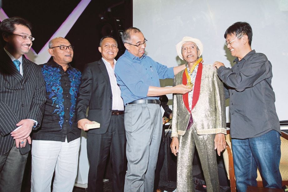 SALLEH menyampaikan anugerah Bintang Legenda kepada Mat Sentol sambil diperhatikan Fauzi (kiri sekali), Khusairi, Jurey dan Aziz.