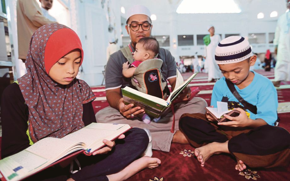 KHAIRUL Anuar bersama keluarganya membaca al-Quran sempena World Quran Hour.