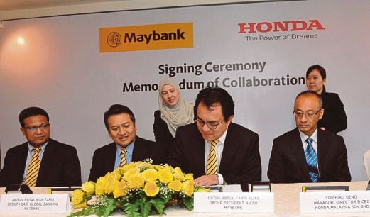 Ketua Pegawai Eksekutif Kumpulan Maybank, Datuk Abdul Farid Alias menandatangani perjanjian sambil disaksikan Hamirullah (kiri) dan Ketua Pegawai Eksekutif Honda Malaysia, Yoichiro Ueno (kanan). 