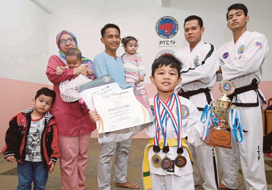Muhammad Absyar Rayyan  bersama keluarganya dan dua jurulatih Rozaidi  dan Mohd Arifin  (kanan). 