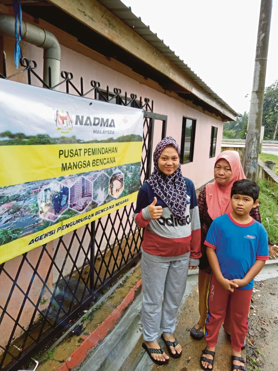    ROZITA  (kiri) bersama ibu dan adiknya ditempatkan di PPS  di Kampung Seberang Batu Badak, Segamat. 