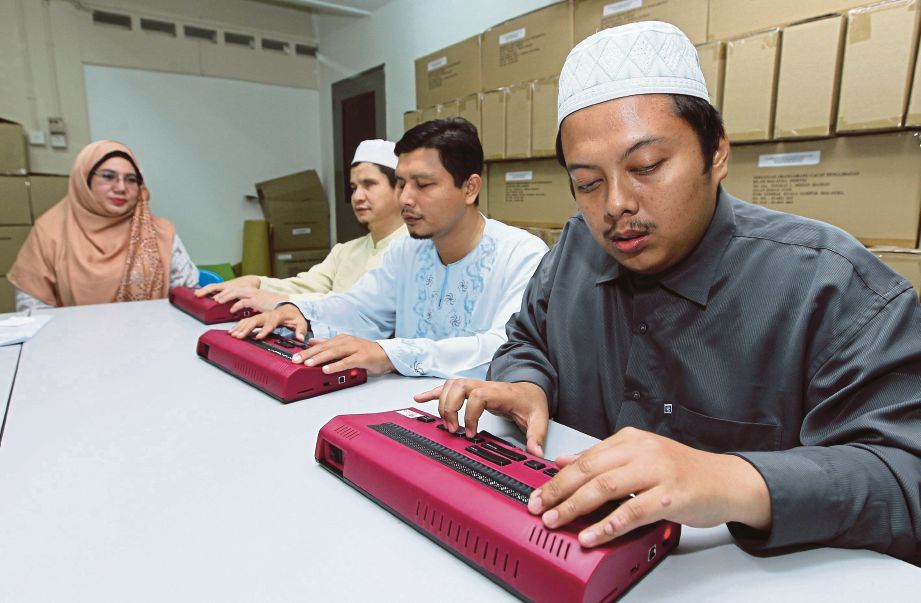  BIBI  (kiri) mendengar  peserta OKU  membaca  al-Quran Braille elektronik sempena Majlis Khatam Al-Quran dan Selawat Perdana.  