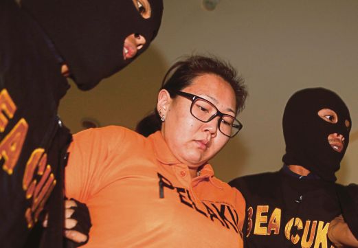 ALEKSANDRA diiringi pegawai kastam selepas cubaannya menyeludup dadah dari Hong Kong digagalkan pihak berkuasa Bali.