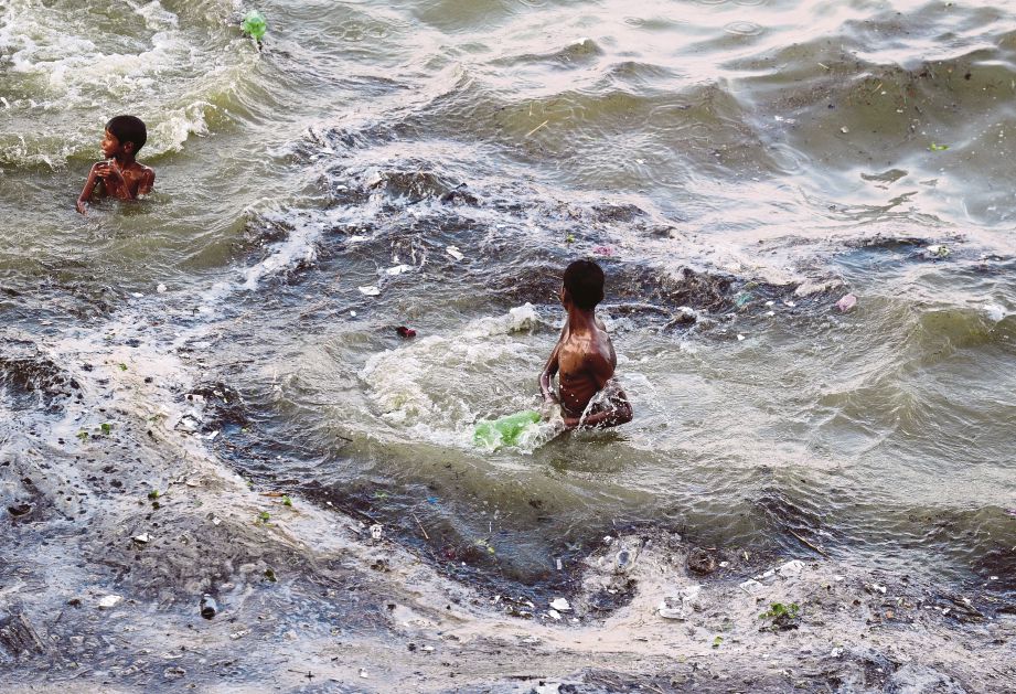 BUDAK lelaki bermain air banjir selepas  Sungai Ganges melimpah akibat hujan lebat di Allahabad.