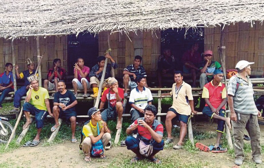 PENDUDUK Orang Asli berkumpul di Kampung Parit sebelum bergerak ke Simpang Kampung Petei, Pos Tohoi.