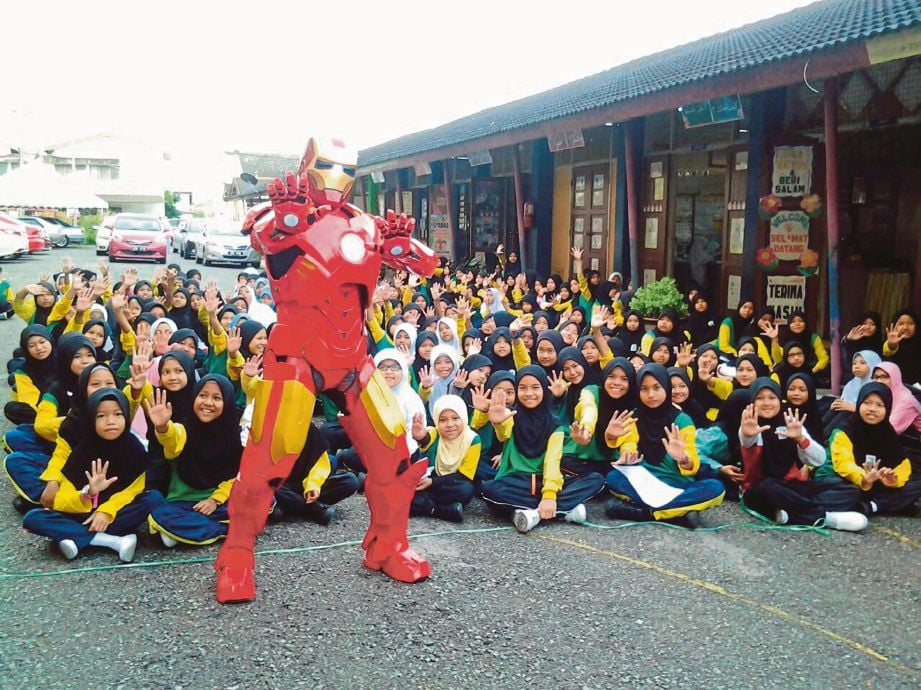 MOHD Faizal memakai sut adiwira Iron Man bersama murid di Sekolah Kebangsaan Jalan Bahagia Temerloh.