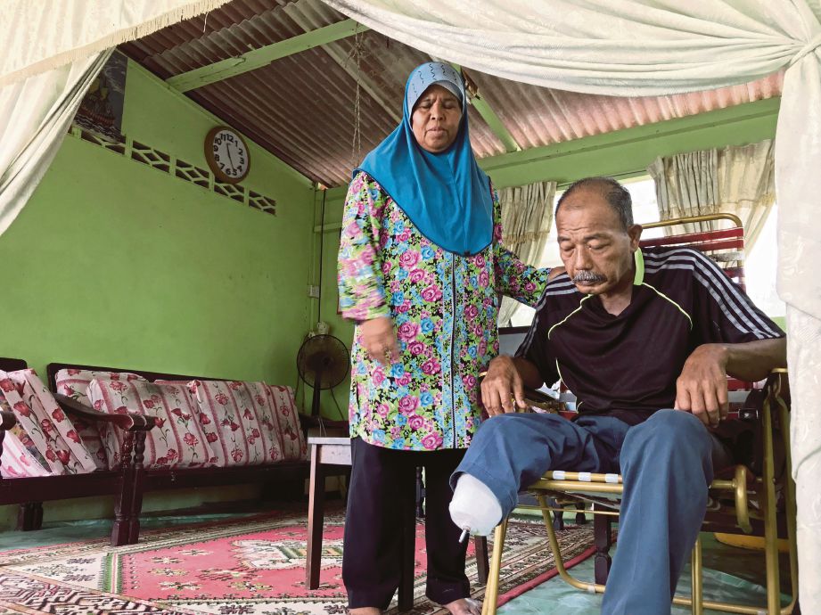 ZAITON  melihat kaki kanan suaminya Mazni yang dipotong akibat penyakit kencing manis.