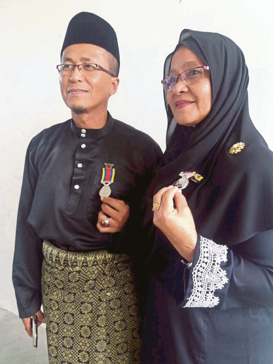  Abdul Talib  dan    Siti Esah   menunjukkan Pingat Jasa Malaysia   yang diterima   pada pada  Majlis Penyampaian PJM   Veteran ATM Johor.  