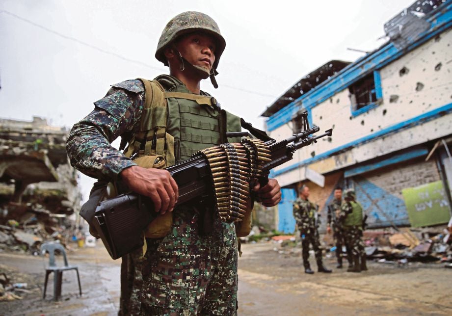 ASKAR kerajaan berkawal di bangunan dan rumah yang musnah akibat pertempuran di Marawi. - Agensi