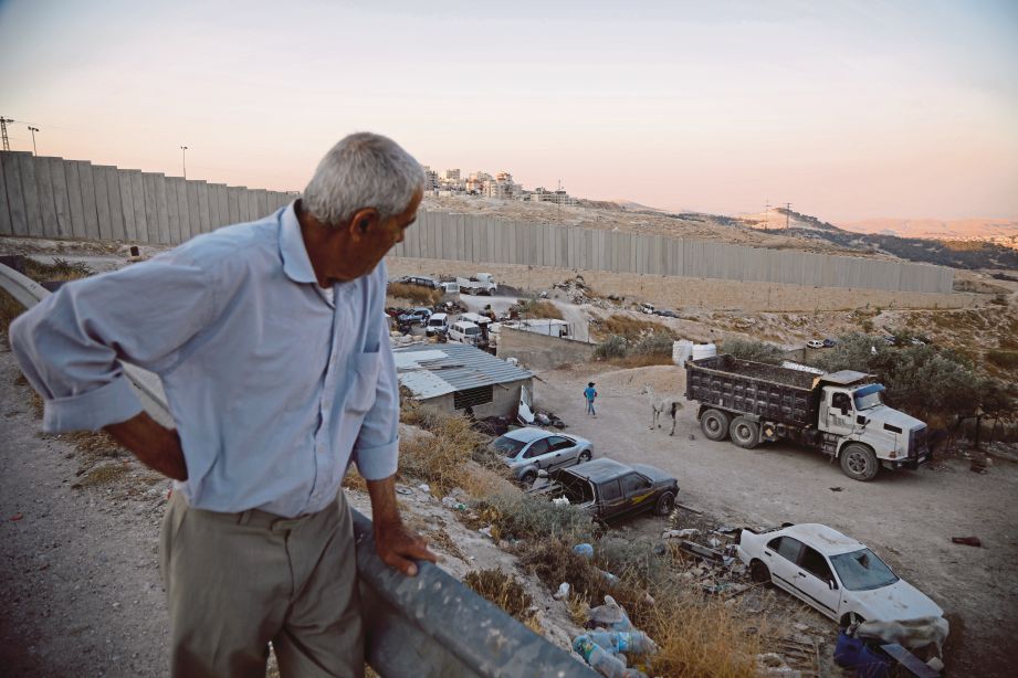LELAKI  Palestin, Ali Farun, 74, berdiri berhampiran tembok  Israel di penempatan Yahudi di bandar al-Eizariya, Tebing Barat. FOTO Reuters