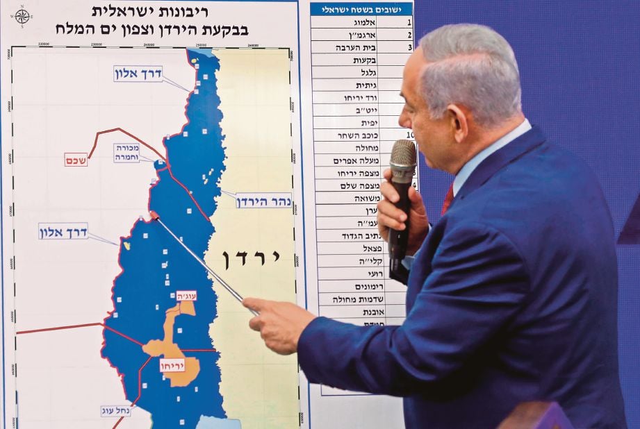 NETANYAHU menunjukkan  peta kawasan yang mahu dirampas ketika sidang media di Ramat Gan,  Tel Aviv, semalam. FOTO AFP