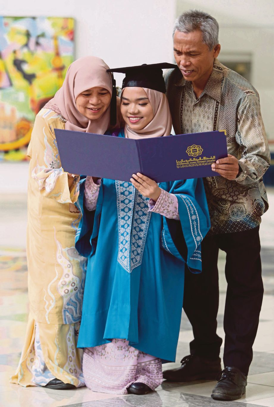 NURINA menunjukkan sijil kepada ibunya Zanariah Ahmad dan bapa Mohd Suhuli Hassan. 