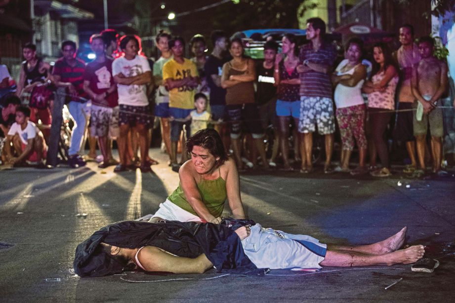 SEORANG wanita meratapi kematian anaknya dipercayai pengedar dadah yang ditembak mati di Manila baru-baru ini. - AFP 