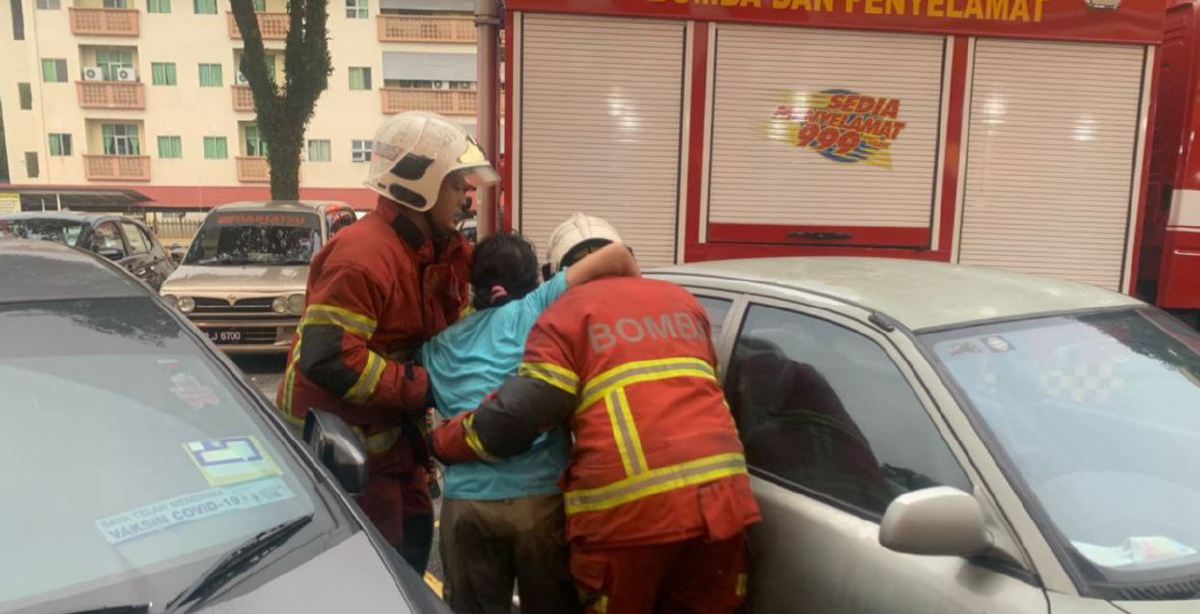 ANGGOTA bomba menyelamatkan seorang daripada wanita warga asing dalam kebakaran di Pandan Mewah. FOTO Ihsan JBPM.