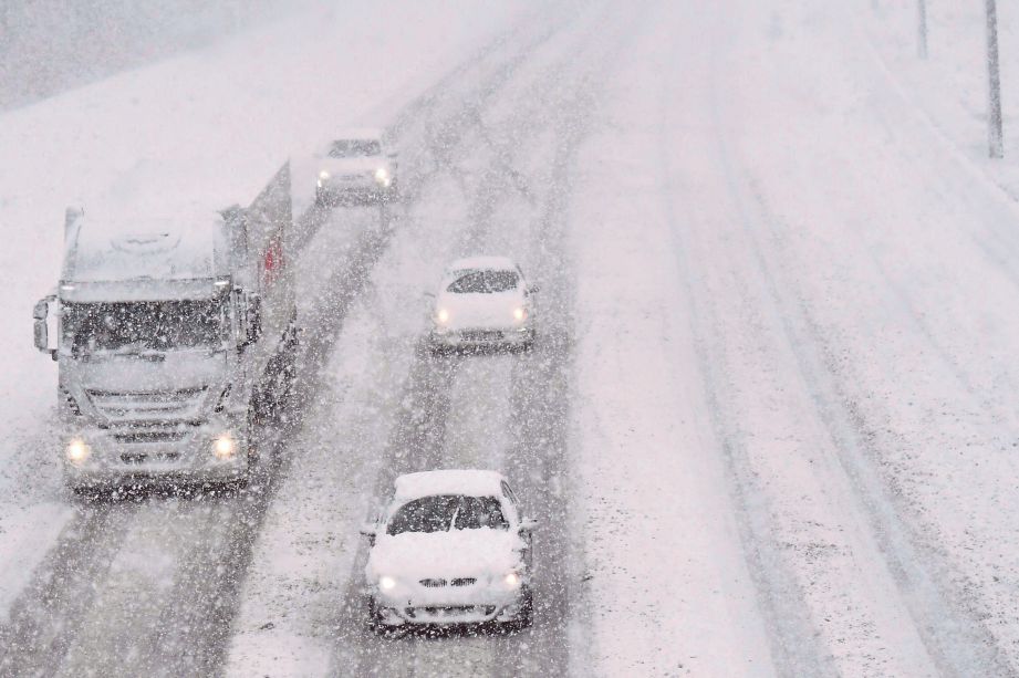 BEBERAPA kenderaan bergerak di lebuh raya E19 di Kontich,  Belgium yang diliputi salji tebal semalam. - AFP
