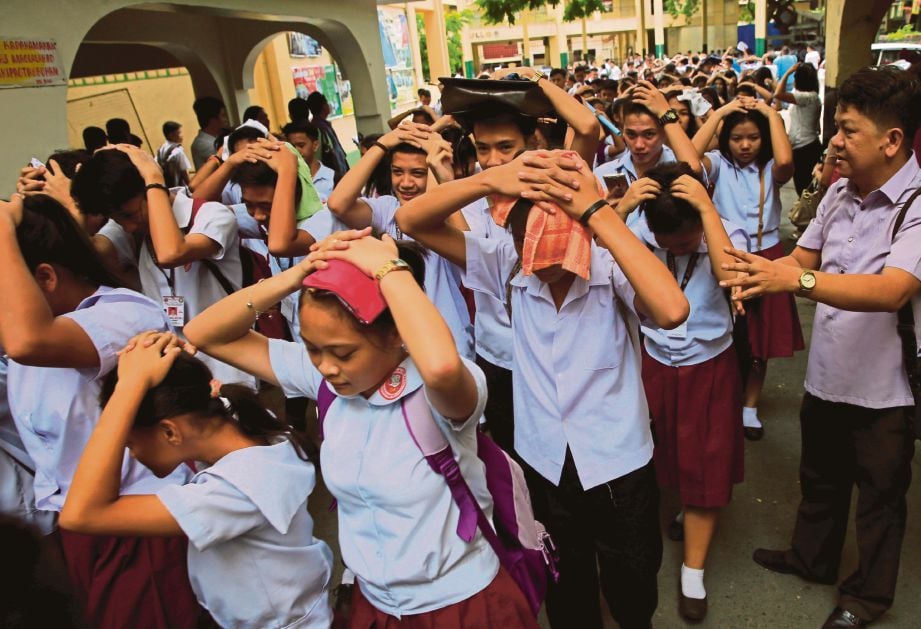 PELAJAR sebuah sekolah  di Manila keluar dari bangunan sekolah susulan gempa bumi  di pulau Luzon semalam. - Reuters