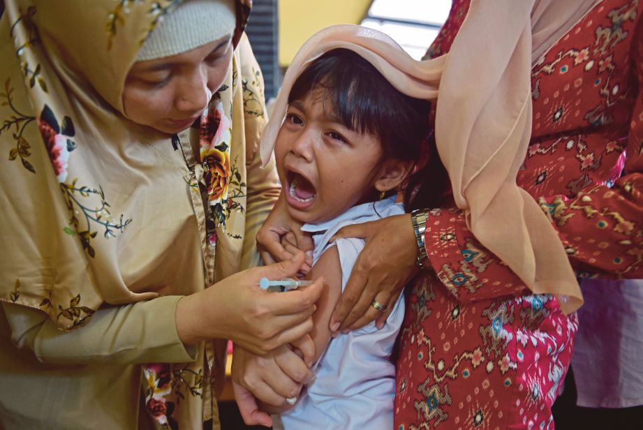 SEORANG kanak-kanak menangis ketika menerima suntikan vaksin difteria di sebuah klinik di Jakarta semalam. - AFP 
