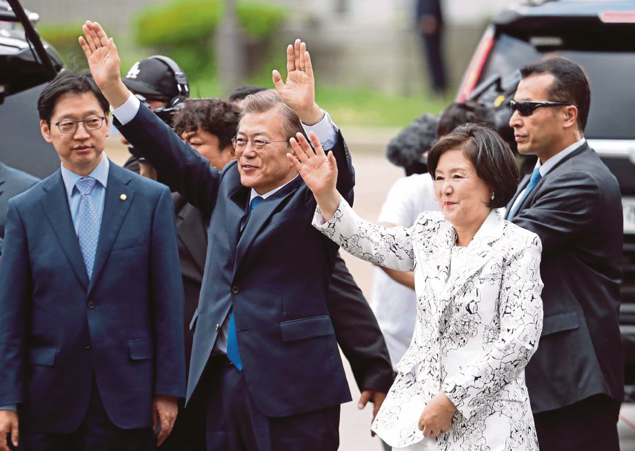 MOON dan isteri, Kim Jung-sook melambai jiran dan penyokongnya ketika mereka tiba di perkarangan Rumah Biru di Seoul, kelmarin.   - AP 