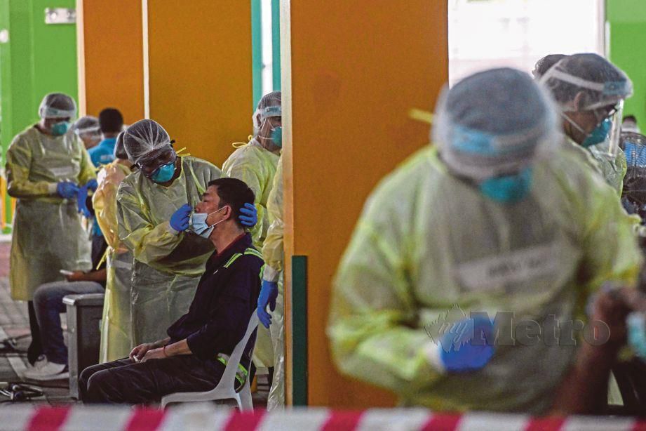 KAKITANGAN Kesihatan Singapura melakukan melakukan ‘swab test’ ke atas pekerja di republik itu. FOTO AFP