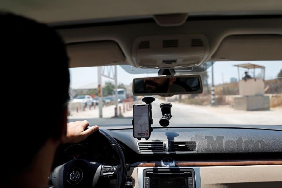 ABDEL Haleem menggunakan Doroob Navigator ketika memandu ke arah sebuah pos kawalan tentera Israel di Ramallah.