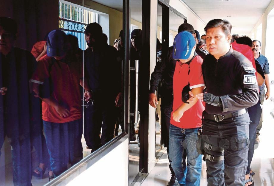 ANGGOTA polis mengiringi enam suspek kes sindiket MyKad palsu yang dipercayai didalangi pegawai kanan JPN Pulau Pinang di Mahkamah Sesyen Georgetown. FOTO/RAMDZAN MASIAM