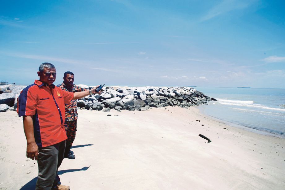  ROSLAN (kiri) menunjukkan lokasi mayat Muhammad Syafiq Farhan yang dijumpai di Pantai Puteri, Tanjung Kling.