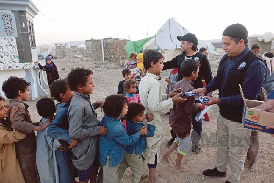  SUKARELAWAN   Iman care menyampaikan  makanan kepada kanak kanak pelarian.