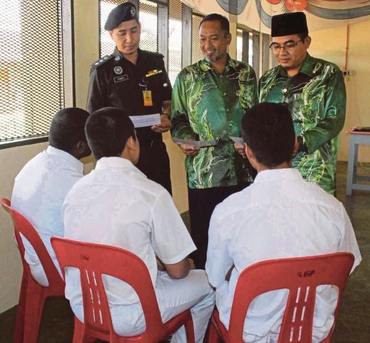Guru dan pegawai penjara beramah mesra dengan tiga pelajar cemerlang SPM Sekolah Integriti Penjara Sungai Petani. 