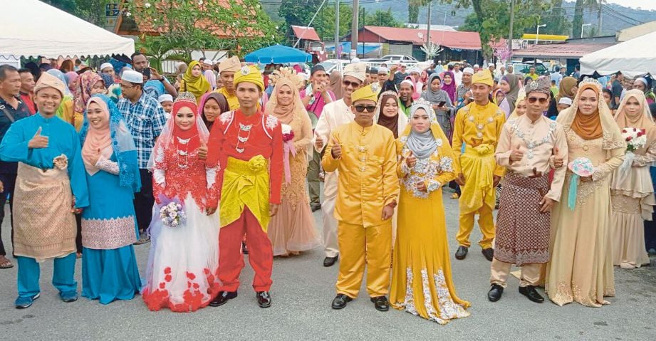 LAPAN pasangan pengantin yang menyertai Walimatul urus Perdana anjuran Jawatankuasa Kariah Masjid Al-Ehsan Kampung Temonyong, Langkawi. Muhammad Aidilfitri dan Siti Nurfitrah dalam bulatan.