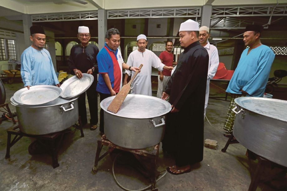 OTHMAN (tiga dari kiri) bersama ahli kariah masjid membuat persiapan akhir sempena Program Ibadah Korban Titipan Kasih Harian Metro.