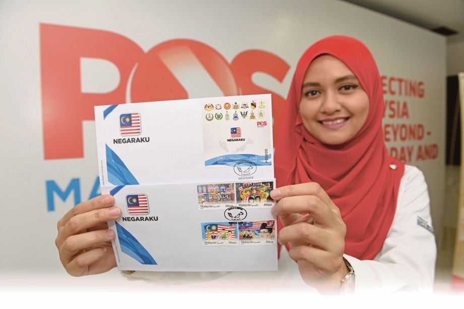 KAKITANGAN Pos Malaysia, Nurshafiqa Mat Kasim menunjukkan setem dan sampul surat keluaran khas ‘Negaraku’. 