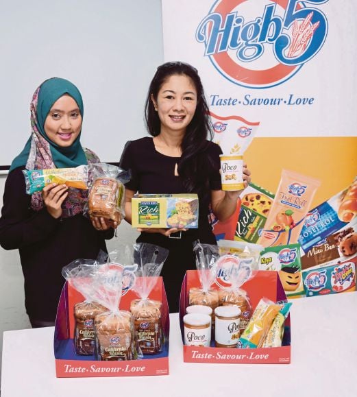 Arlyn (kanan) dan Eksekutif Pemasaran Hi-5 Siti Athirah Shahadat bersama produk roti Hi-5. 