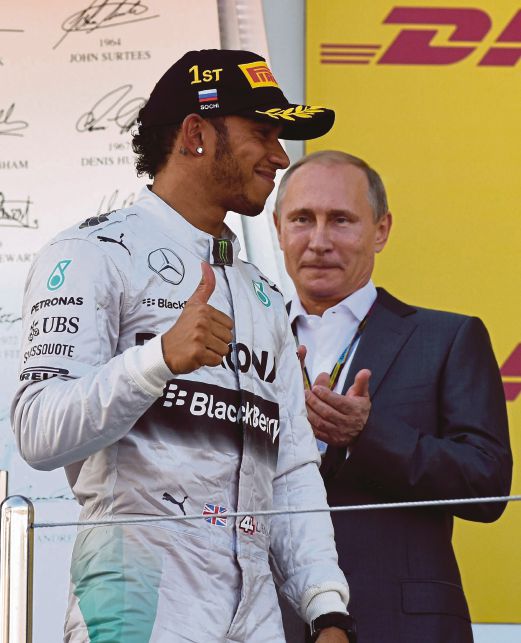 HAMILTON (kiri) menunjukkan tanda bagus sambil diperhatikan Presiden  Vladimir Putin selepas muncul juara Grand Prix  Russia.