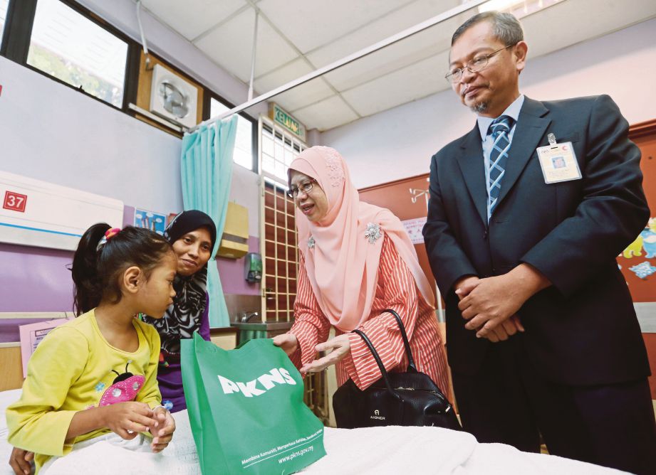 Noraida (dua kanan) dan Dr Md Fikri menyampaikan sumbangan kepada Nurul Damia Syuhada Nasir bersama ibunya Siti Aishah Jamaluddin di wad kanak-kanak Hospital Kajang.