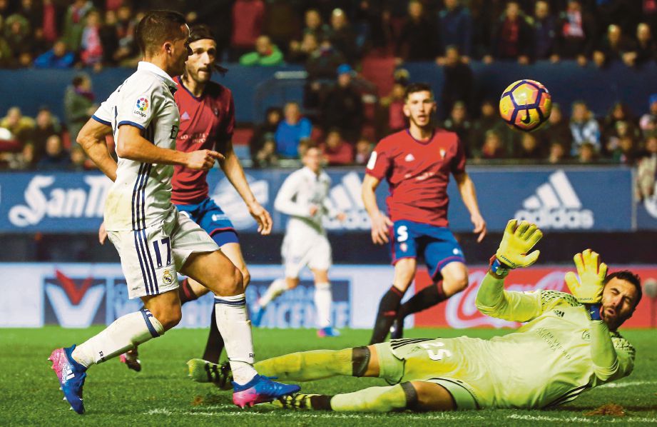 VAZQUEZ (kiri)  menolak bola melepasi jangkauan penjaga gol Osasuna, Sirigu.  