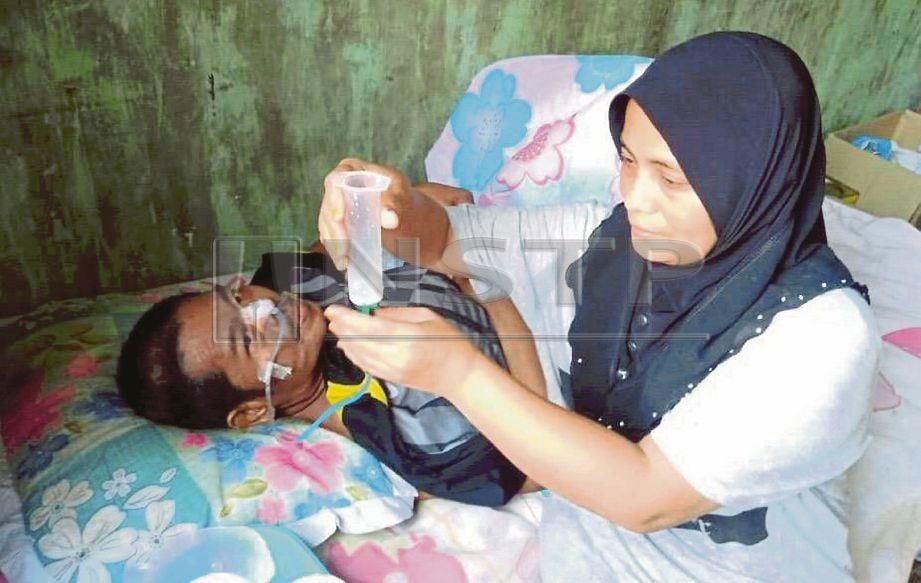 SITI Zaharah  memberi Mohd Saufi minum susu khas melalui tiub yang dipasang di hidung.