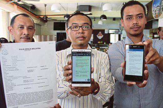 Saiful (tengah) bersama  pekerjanya  menunjukkan laporan polis dan  laman sosial  berhubung skim cepat kaya yang menggunakan nama  syarikatnya  di Kota Bharu, semalam.