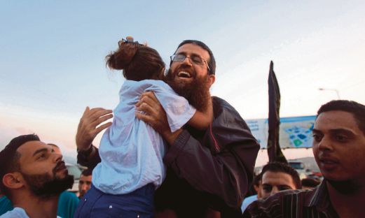 KHADER memeluk anak perempuannya selepas dibebaskan dari penjara Israel di Tebing Barat, semalam. 