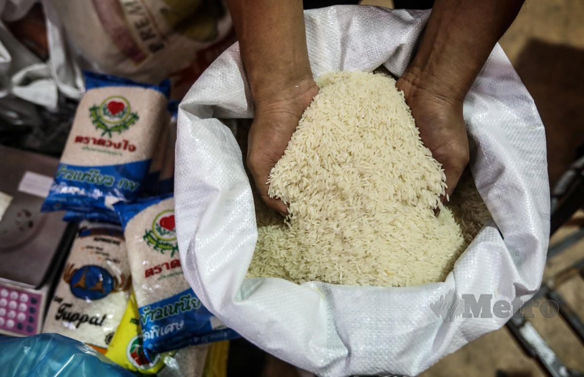 PENIAGA Wan Ahmad Fadhil Wan Jaafar, 37  menyusun beras untuk dijual kepada pelanggan di Pasar Kedai Payang, Terengganu. FOTO Ghazali Kori.