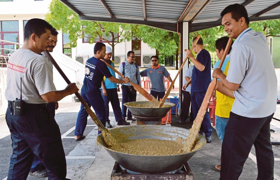 KAKITANGAN NSTP Prai sedang mengacau dan memasak bubur asyura dalam Program Memasak Bubur Asyura yang dilakukan secara gotong-royong.